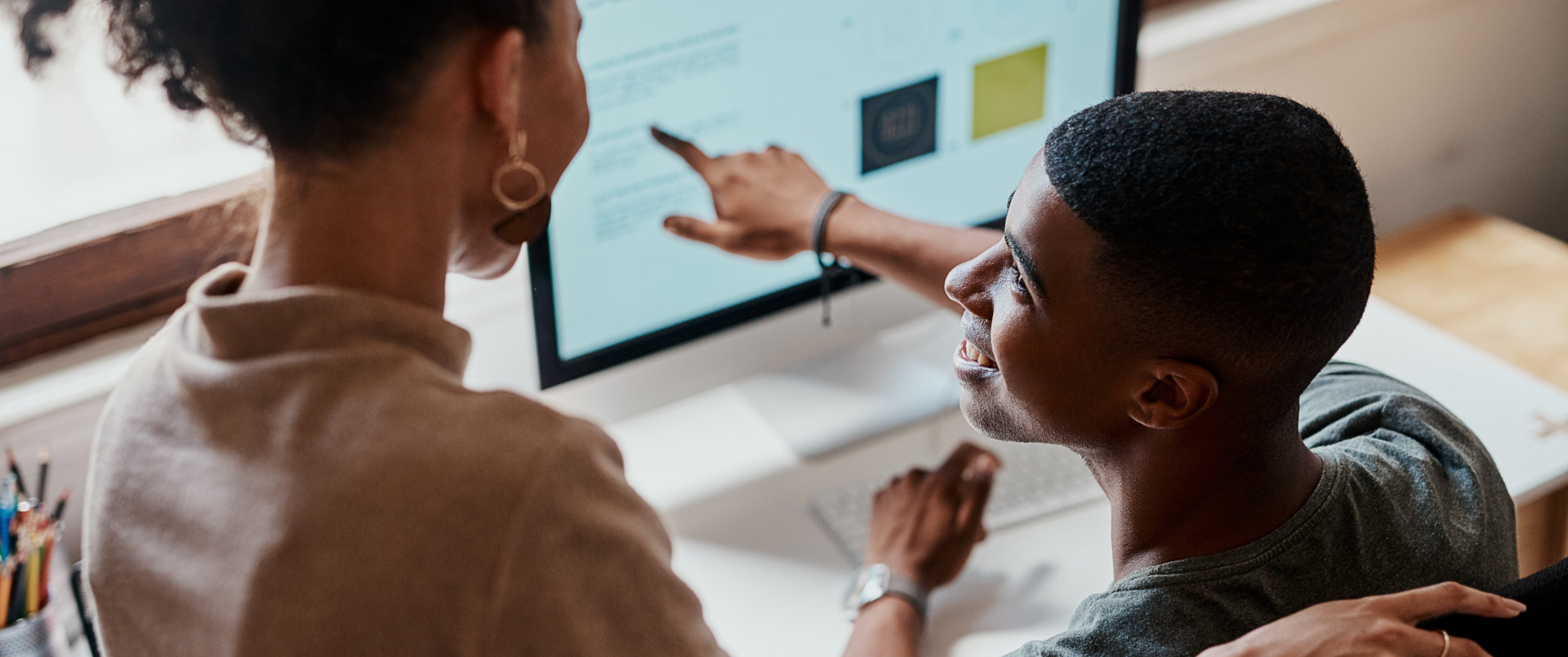 Two people are looking at a computer screen
