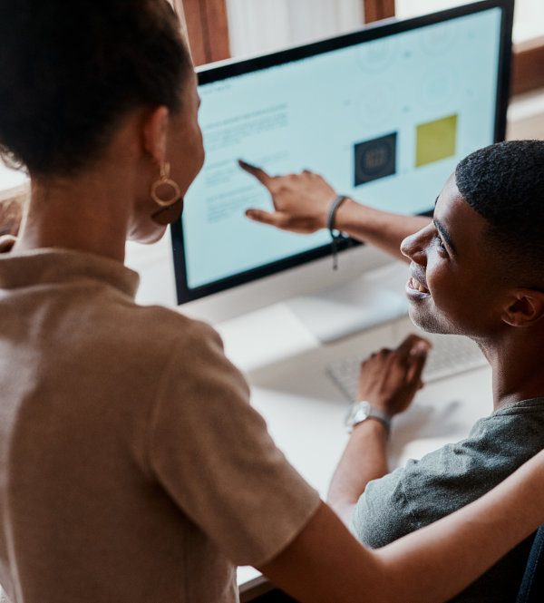 Two people are looking at a computer screen